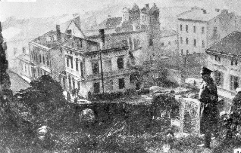 Photograph of German officer overlooking the Great Synagogue which burned the day before.