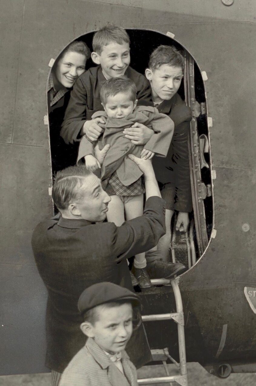 Cesia Szajnzicht (back left) pictured arriving in the UK with her brother Moniek (back right).