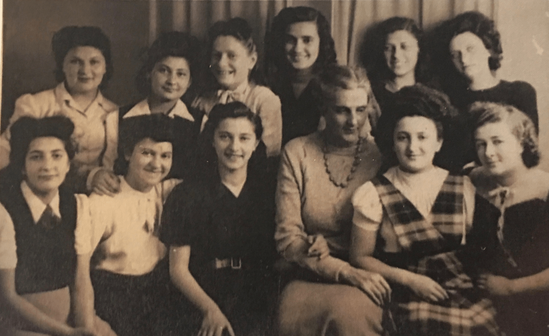 Photograph of the Girls with their English teacher. Stefa Manela is second to the left on back row and Adela Kaufman is wearing a chequered dress in the front row.