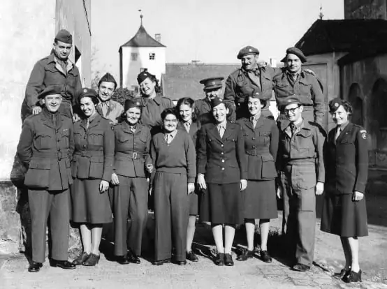 Photograph of Staff at Kloster Indersdorf. First row from left: Harry Parker, Greta Fischer, unidentified, Helen Steiger, Director Lillian D. Robbins, unidentified, André Marx, Marion E. Hutton. (second row from left) John Gower, Dr. Gaston Gérard, unidentified, Mary W. Taylor, unidentified and the two French drivers, Gustave de Sile and Lucien Picou.