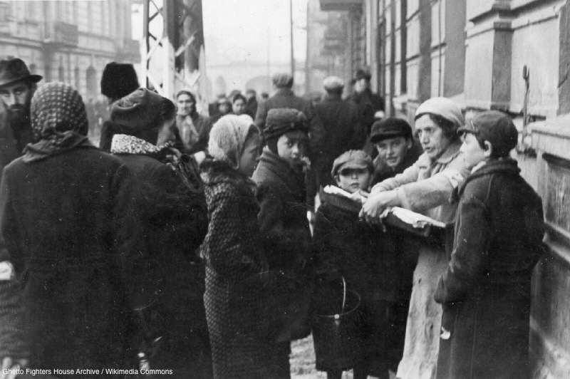 Photograph of a woman selling potato pancakes in the Będzin Ghetto in occupied Poland.