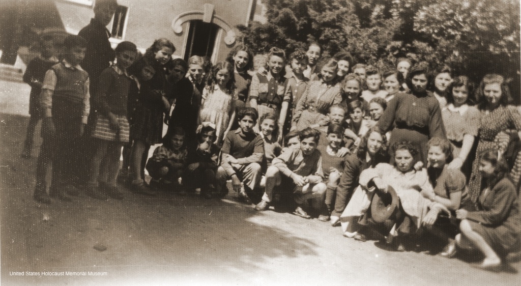 Photograph of Group portrait of members of the orphans transport during their sojourn in France on their way to England in Davreil, France, 1946. Among those pictured are Serena Lampert, Mermelstein, E. Zelovic, Vermes, Markovits, Weinberger, Moshe Lampert, Willie Zelovic, Weiss, Davidovic, Lebovic, Slomovic, Birnbaum, Zelikovic and Bohm.